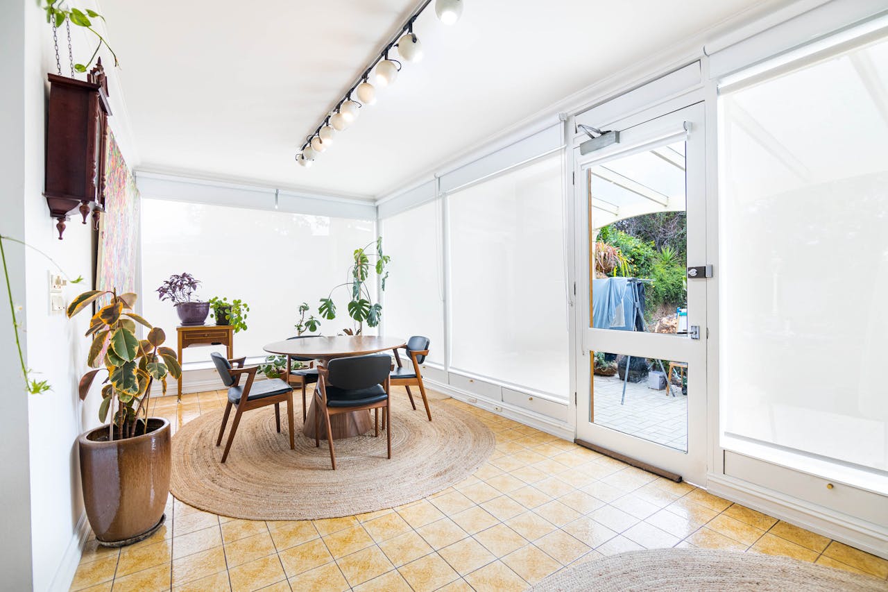 hero-img-02 Spacious and well-lit indoor dining area in Melbourne with minimalist decor and lush indoor plants.